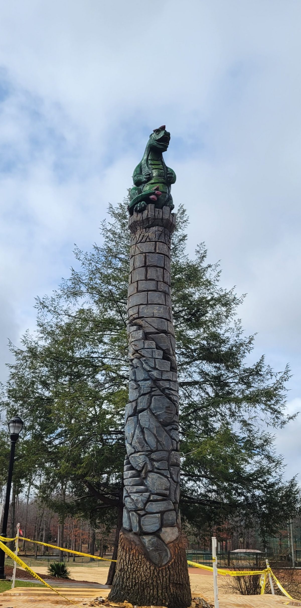 A tall tower carved from a single tree with a dragon on top.