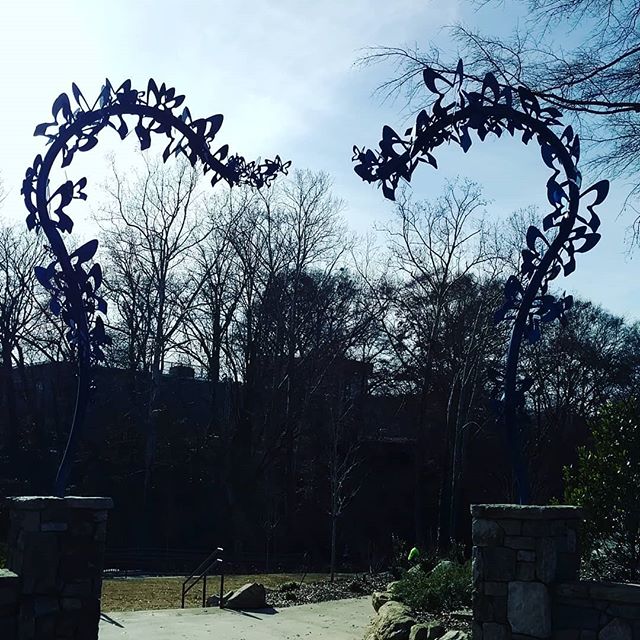 An archway made of brick and metal butterflies